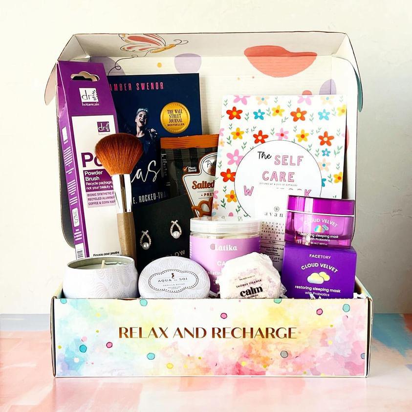 A past GenGlow Box filled with a makeup brush, candle, shower steamer and sleeping mask