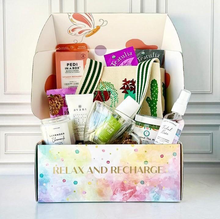A past GenGlow Box filled with a pedicure set, teas, a candle and a cotton tote