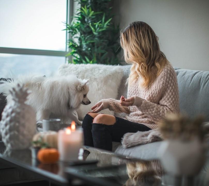 A woman relaxing at home by candlelight with her dog